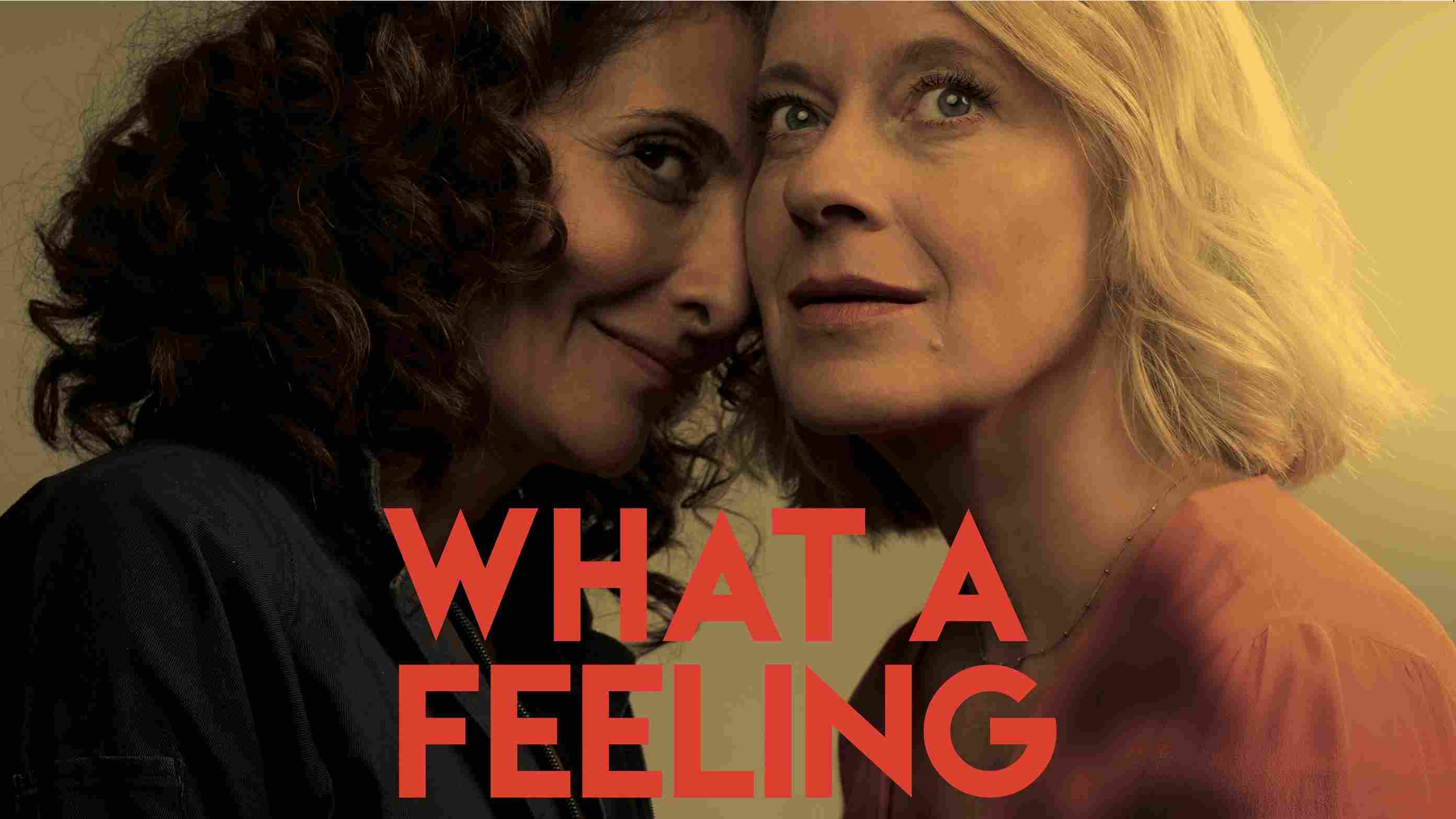 Filmplakat f�r 'What a Feeling' mit einer Nahaufnahme von zwei Frauen in einem intimen Moment, mit warmen Farben und einem roten Titeltext.